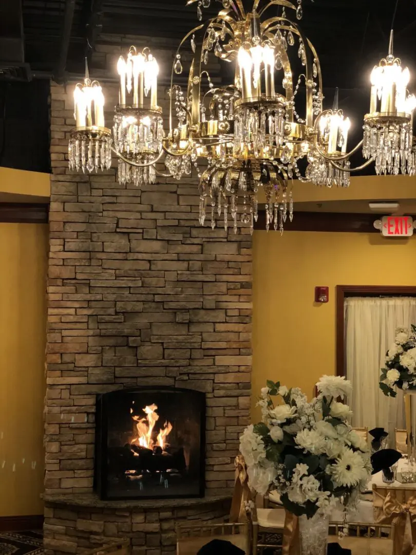 A fireplace in the center of a room with a chandelier.