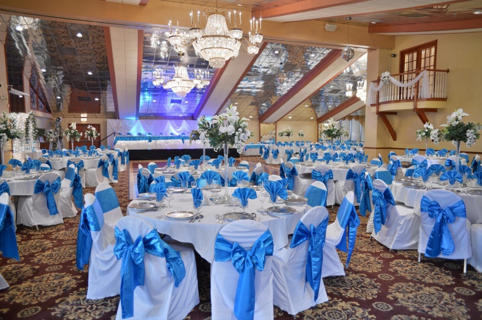 A banquet hall with tables and chairs set up for a wedding.