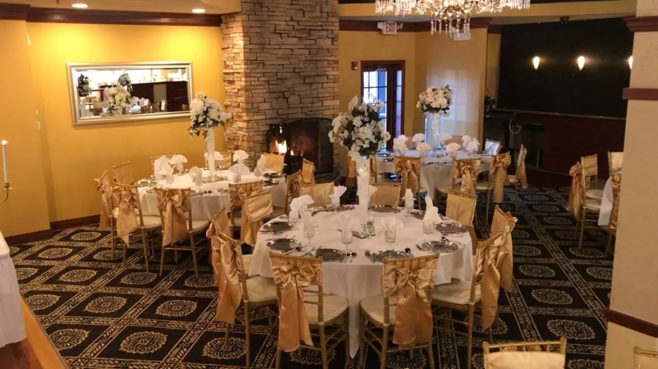 A banquet hall with tables and chairs set up for a wedding.