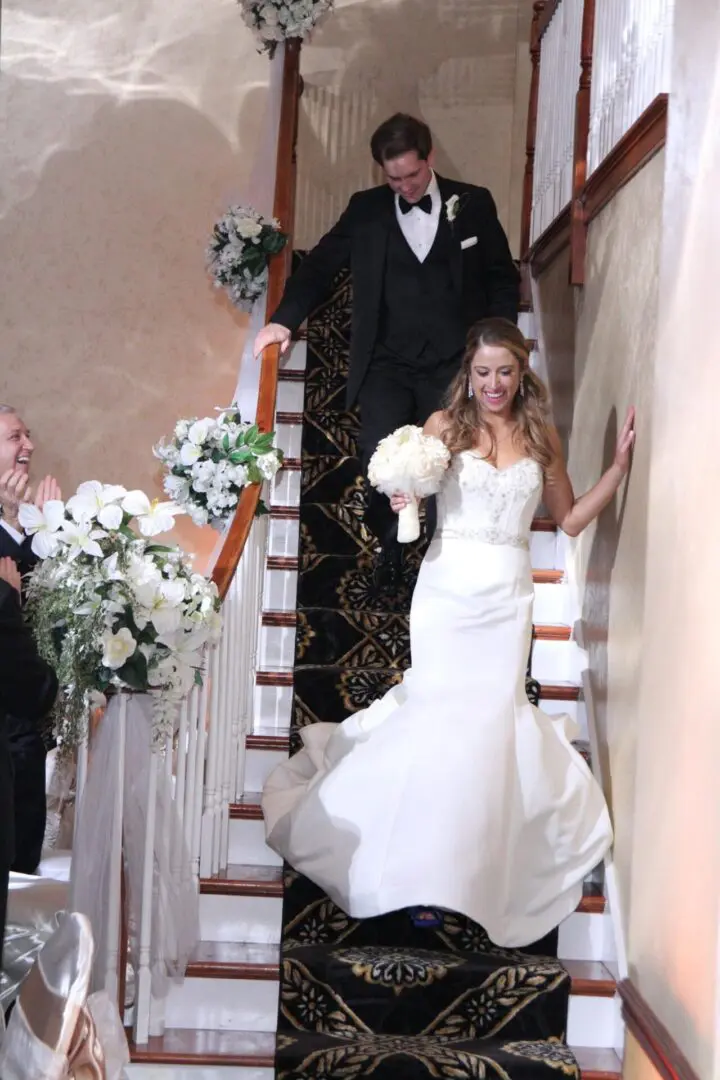 A bride and groom walking down the stairs.